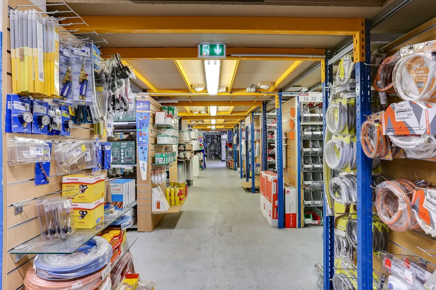 Allée du magasin avec raccords, flexibles et outillage en rayon